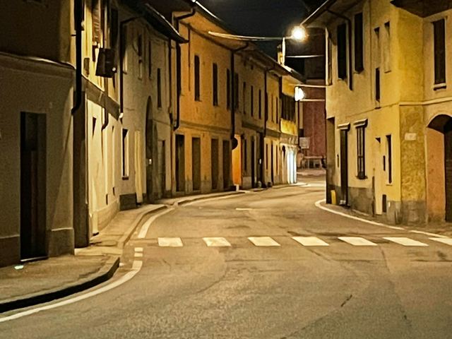 A quiet, empty town street at night under warm street lights