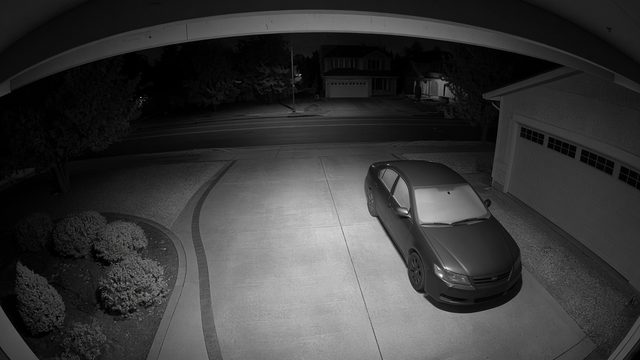 Demo night-vision camera view of a driveway with a parked car